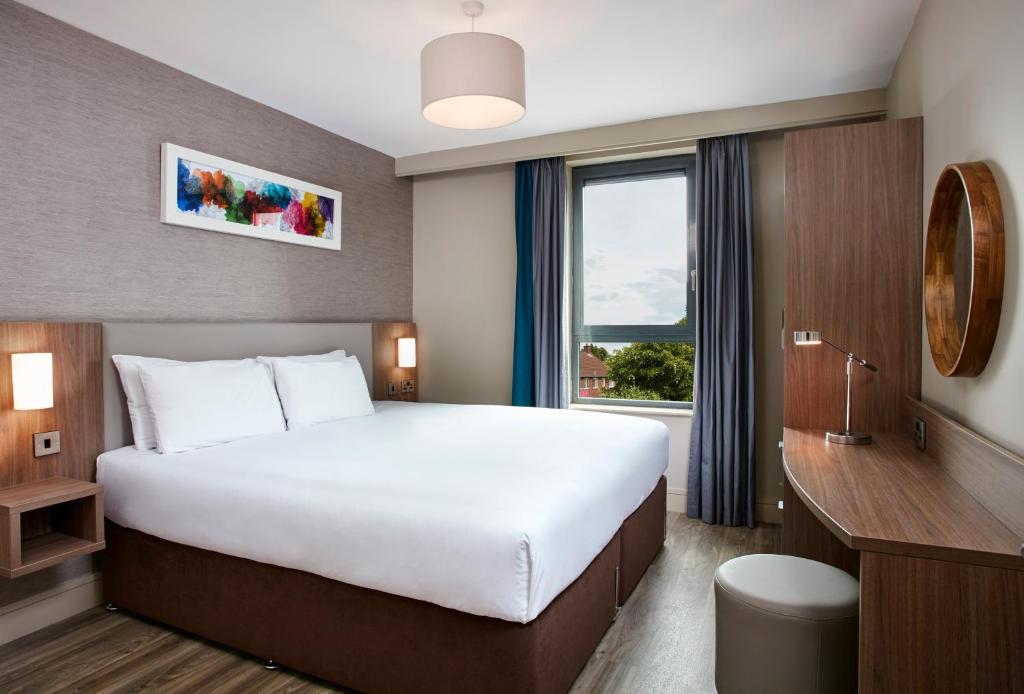 a bedroom with a large bed and a large window at Cordia Serviced Apartments in Belfast