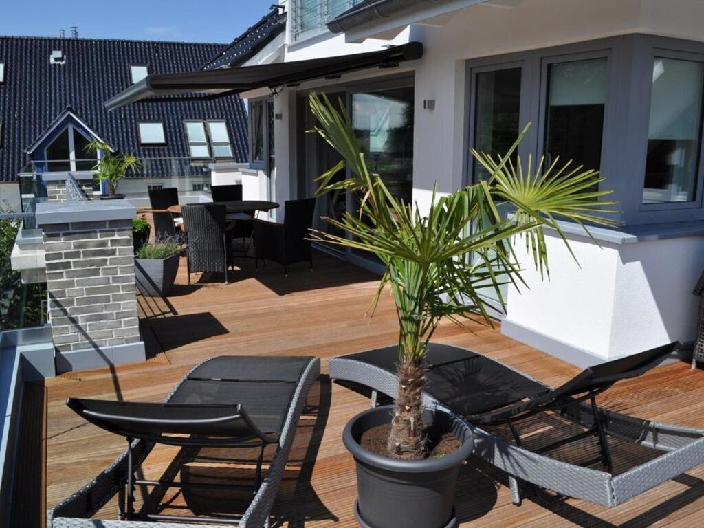 un patio con 2 sillas y una maceta en The House of Port Haf 2, en Niendorf