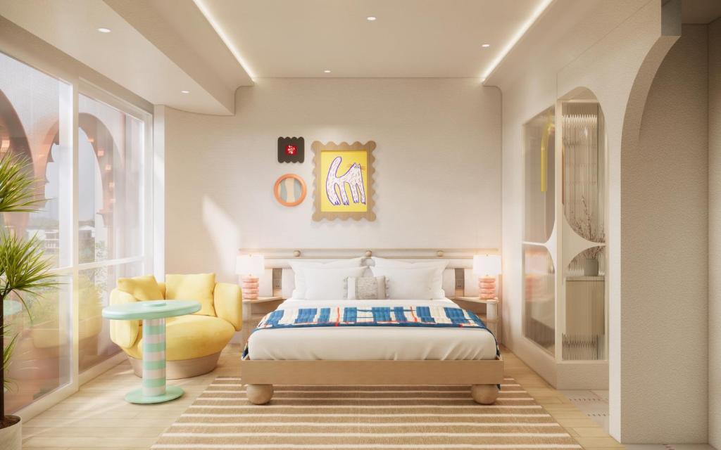 a bedroom with a bed and a yellow chair at Savvy by M Village Hai Ba Trung - Saigon Downtown in Ho Chi Minh City