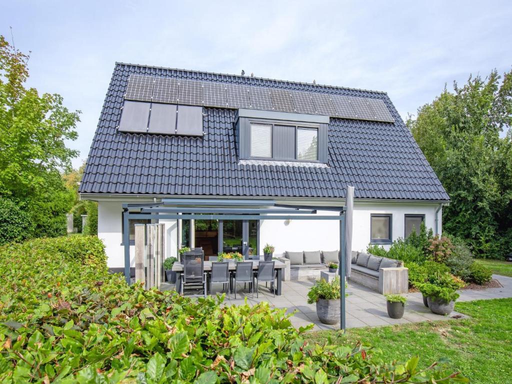 una casa con techo y patio en Lovely villa on the edge of the forest, en Westermient