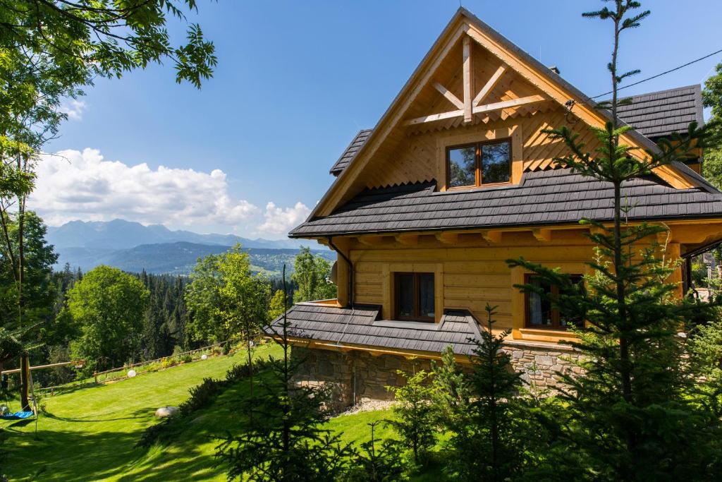 a log house with a gambrel roof on a hill at udanypobyt Dom Forest Prestige House in Rzepiska