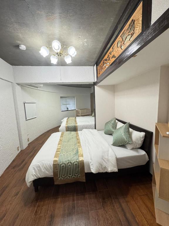 a bedroom with two beds and a ceiling at MARU KIX House in Izumi-Sano