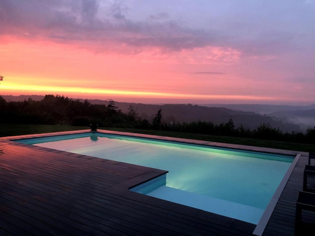 una piscina con un tramonto sullo sfondo di Beach House in Ardennes a Chaudfontaine