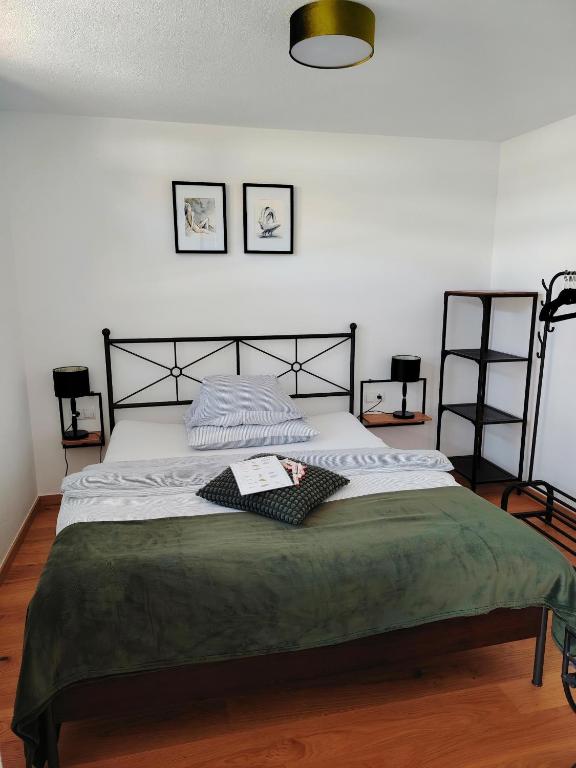 a bedroom with a large bed with a green blanket at #HeimatLiebe in Imst