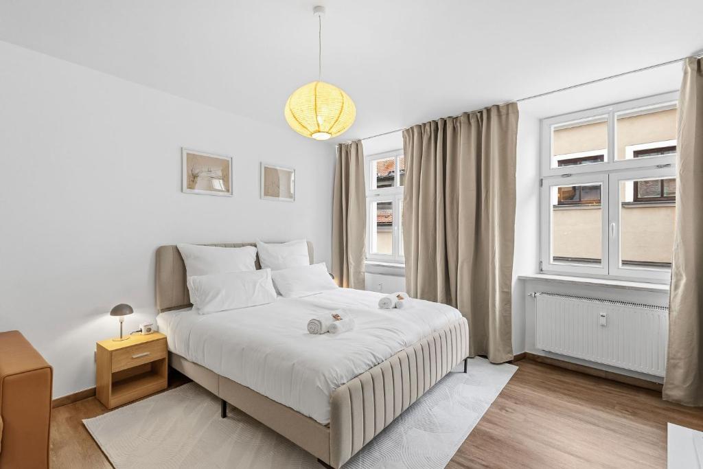 Un dormitorio blanco con una cama y dos ventanas. en Apartment in Straubing, en Straubing