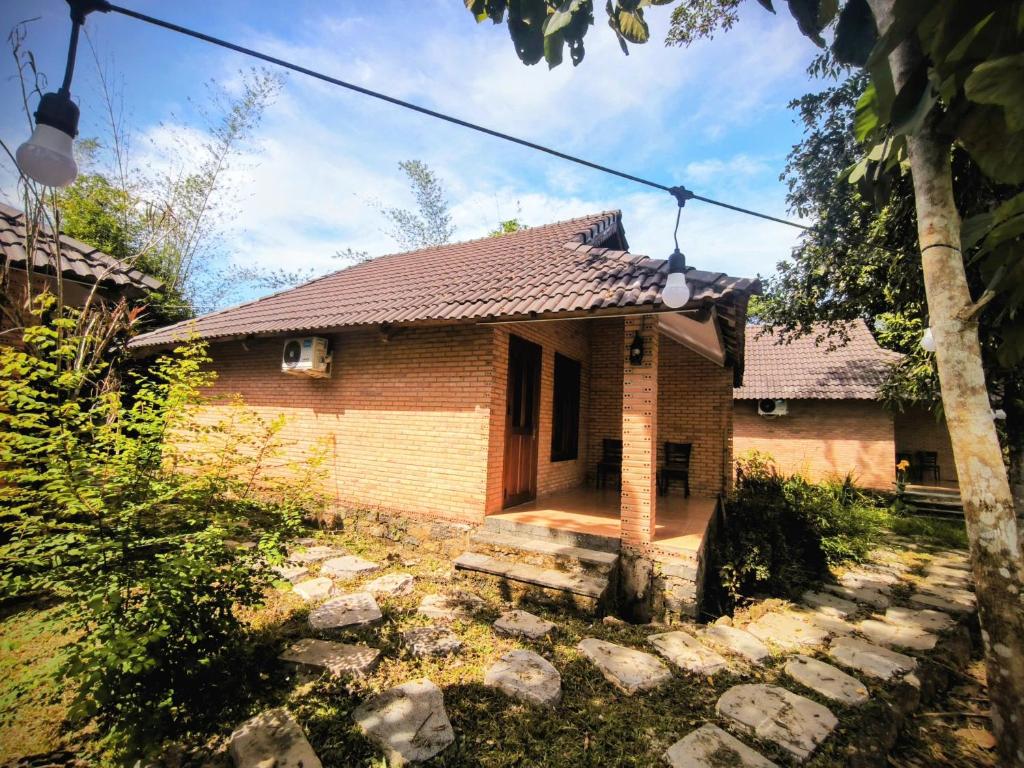 a small brick house with a porch in a yard at Nam Cat Tien Retreat in Tân Phú