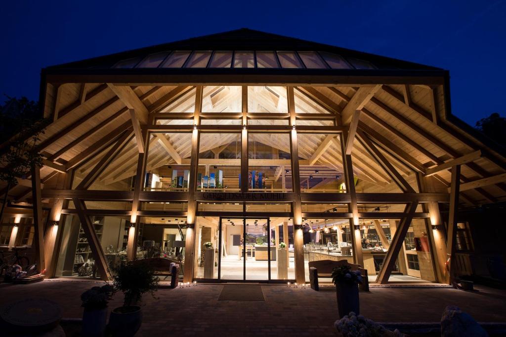 un gran edificio con una gran ventana de cristal por la noche en Gästehaus der Geroldsauer Mühle en Baden-Baden