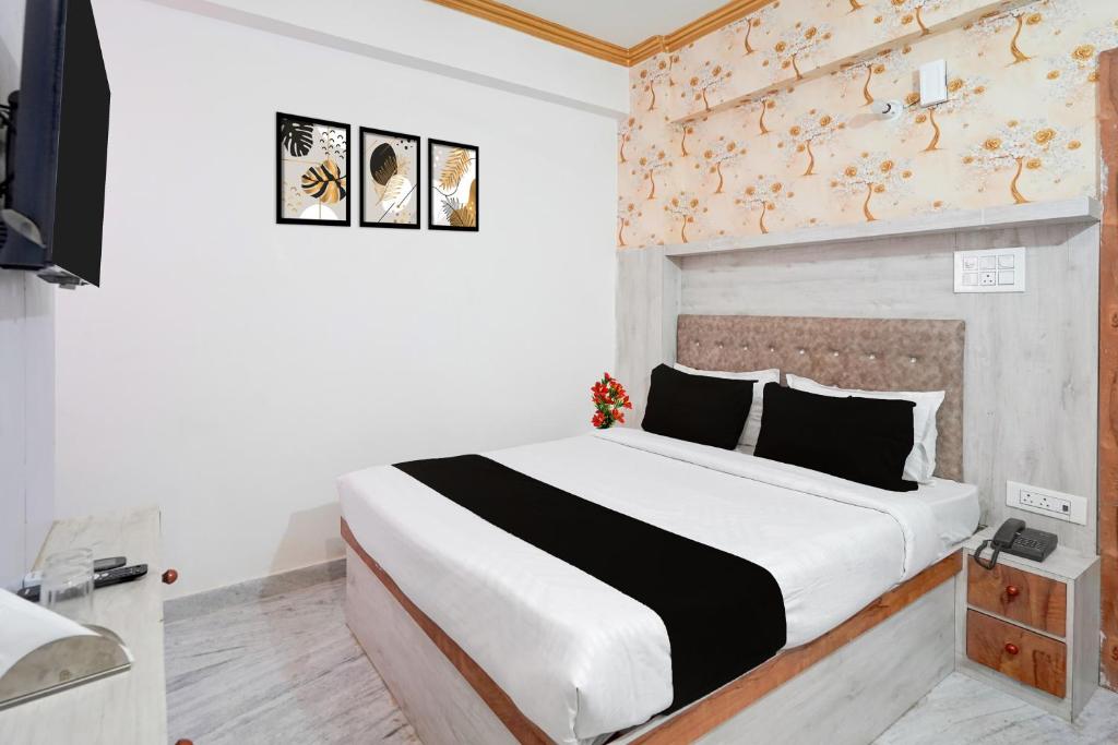 1 dormitorio con cama blanca y edredón blanco y negro en Collection O Digha Ghat Formerly Hotel Shahnai, en Bankipur