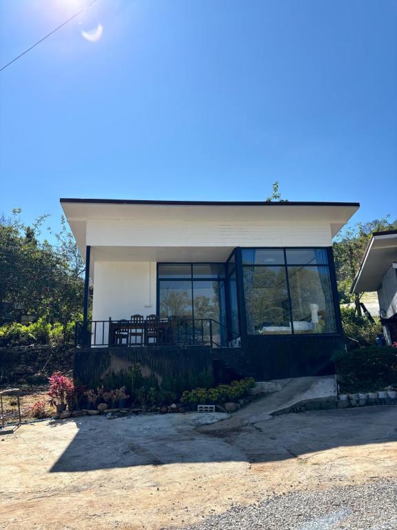 a small house with a large window on it at อินทนนท์ บ้านพักเล่าจู Inthanon Laoju House in Ban Na Yang