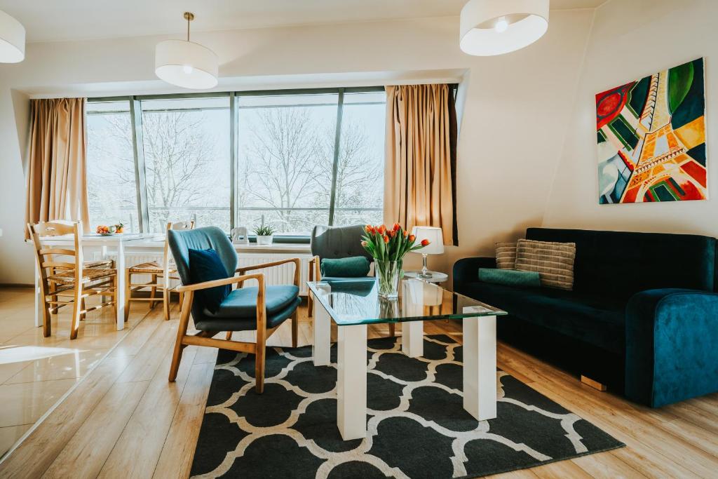 a living room with a couch and a table at VisitZakopane - Cristal Apartment in Zakopane