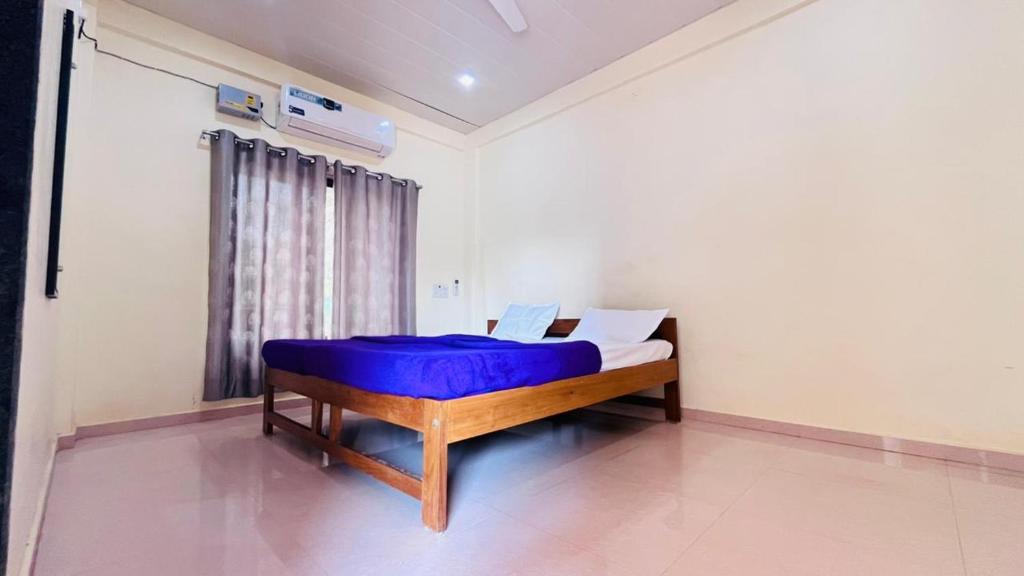 una camera con un letto con una coperta blu sopra di Samarth Beach Resort a Malwan