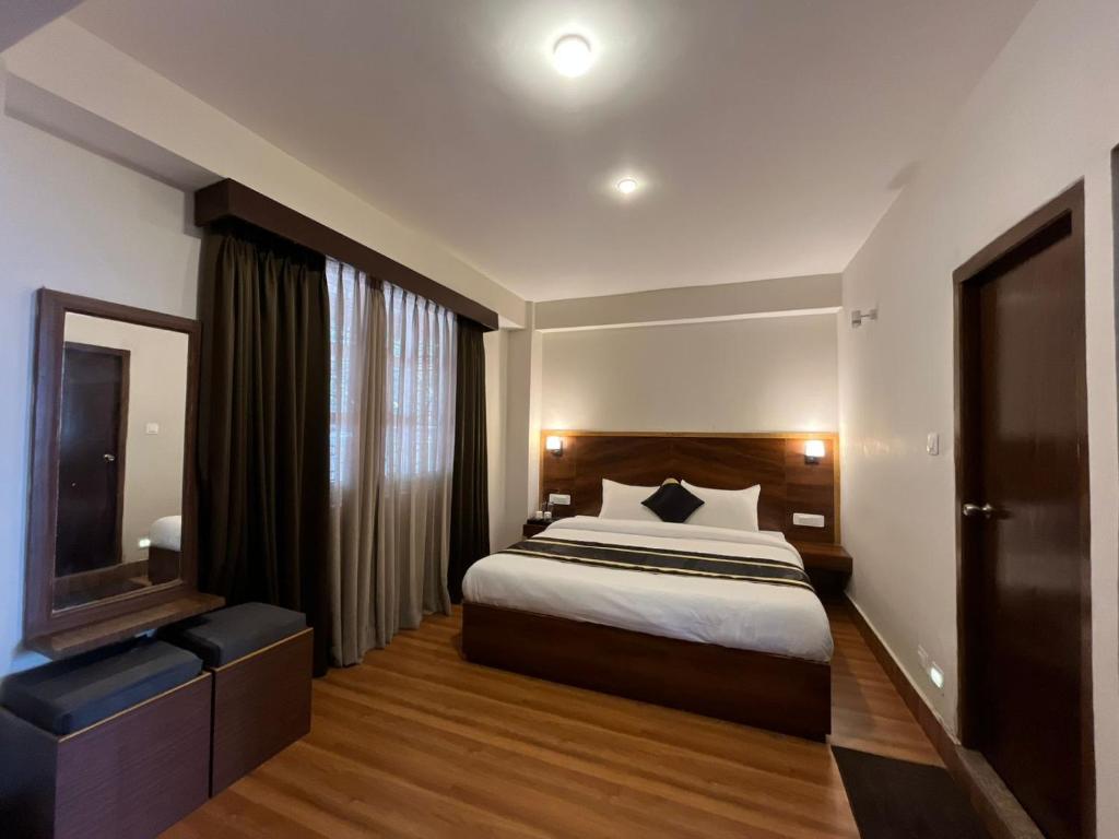 ガントクにあるHotel Freesia Staysのベッドとテレビがあるホテルの部屋