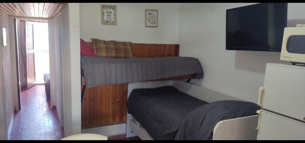 ein kleines Schlafzimmer mit einem Bett und einem Fernseher in der Unterkunft Gesell130 in Villa Gesell