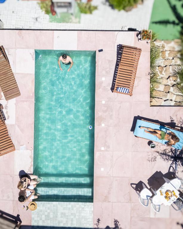 an overhead view of a swimming pool with people in it at Pousada SáGuest in Praia do Rosa