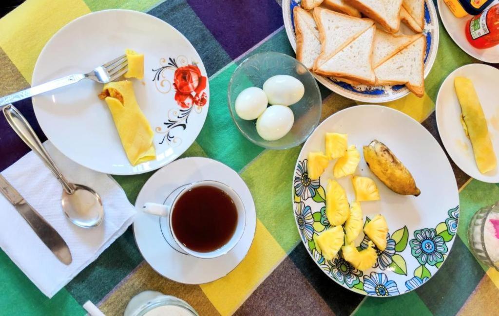 a table with plates of food and a cup of coffee at Private Beach House in Mirissa in Mirissa