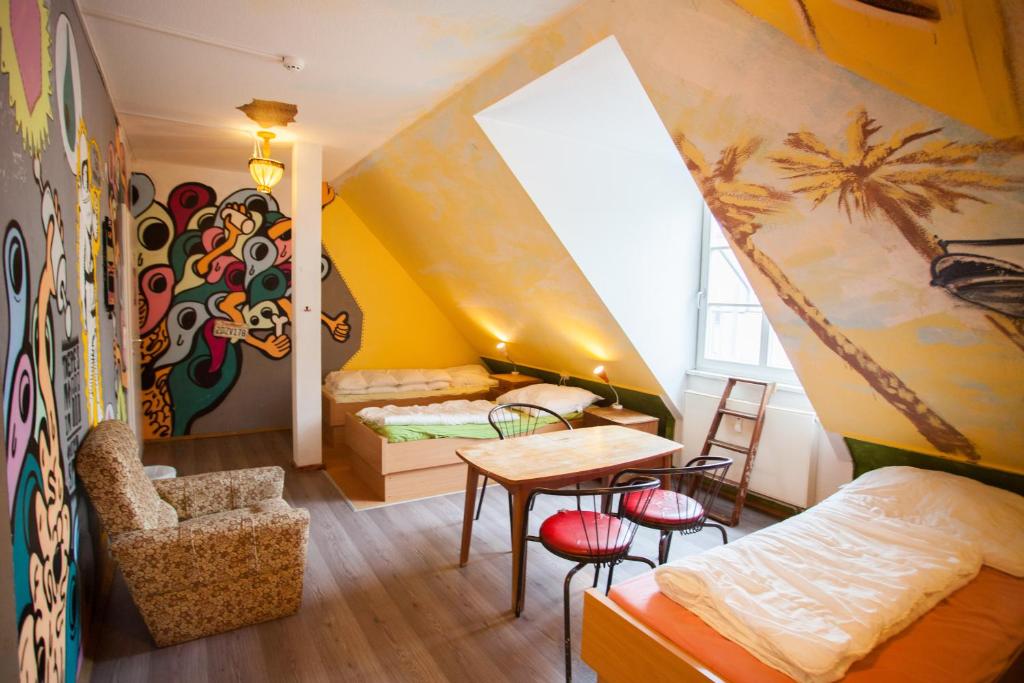 una camera con soffitto giallo e una stanza con tavolo e sedie di Labyrinth Hostel Weimar a Weimar