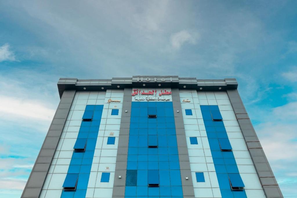 a tall building with blue windows and a sky at Hotel Gardenz View 1 in Taif