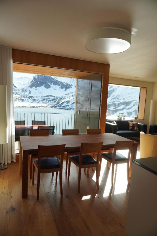 Exklusive Wohnung mit Panoramasicht auf Melchsee-Frutt في فروت: غرفة طعام مع طاولة وكراسي وجبال