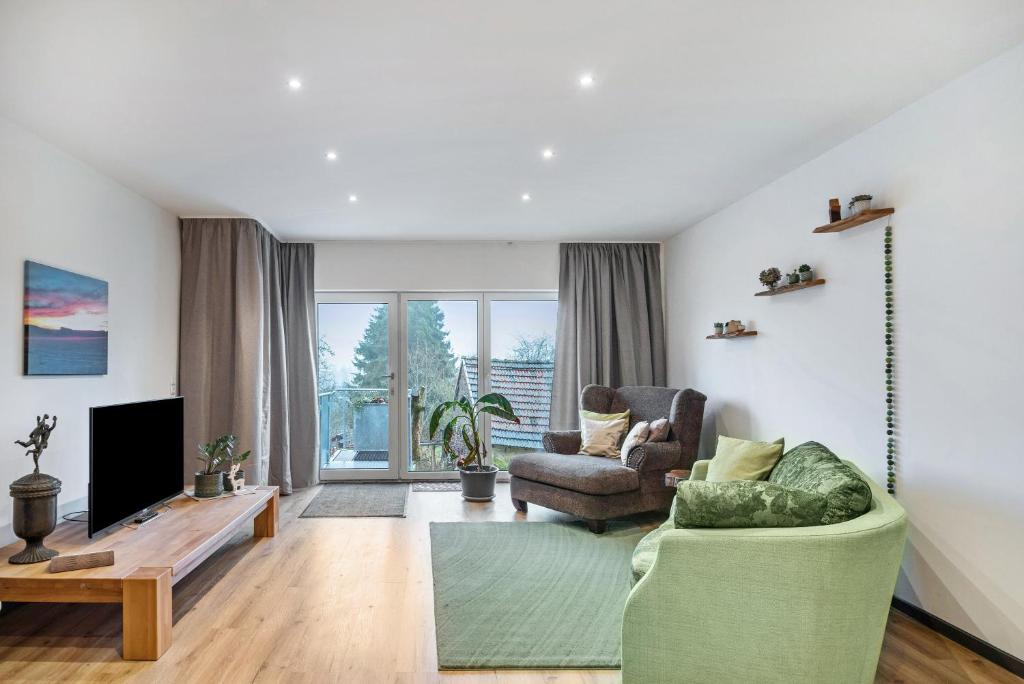 ein Wohnzimmer mit zwei Stühlen und einem Fernseher in der Unterkunft Ferienwohnung Eifelzauber in Willwerscheid