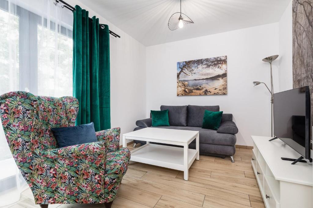 a living room with a couch and a tv at Charming Little Laguna Apartment with SPA & Fitness by Noclegi Renters in Międzywodzie