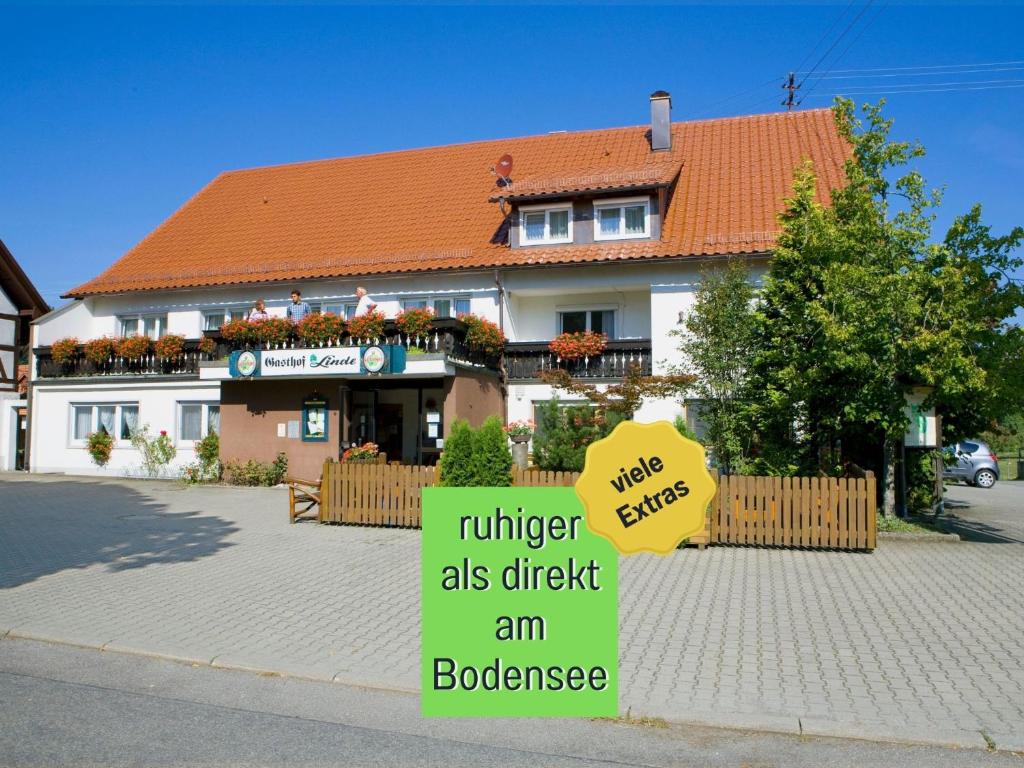 a sign in front of a building with a house at Landgasthof Linde - In ruhiger, ländlicher Umgebung in Deggenhausertal