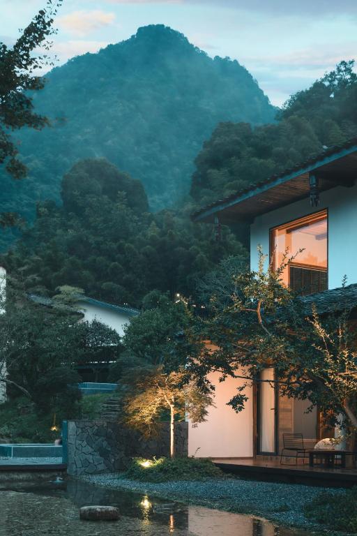 a house with a view of a mountain at YunXi ChanYi Forest Soup Spring Resort Hotel ,Provides pick-up service and tea leaves,Drink Chinese wild tea leaves in Emeishan City