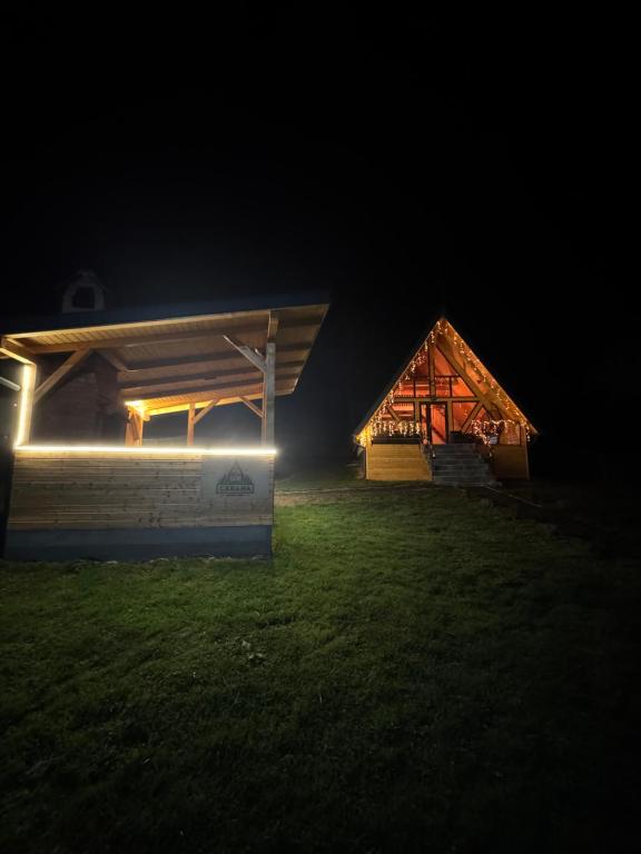 ein Haus mit Lichtern auf dem Gras in der Nacht in der Unterkunft Cabana Bucegi View A-Frame Bran in Predeluţ