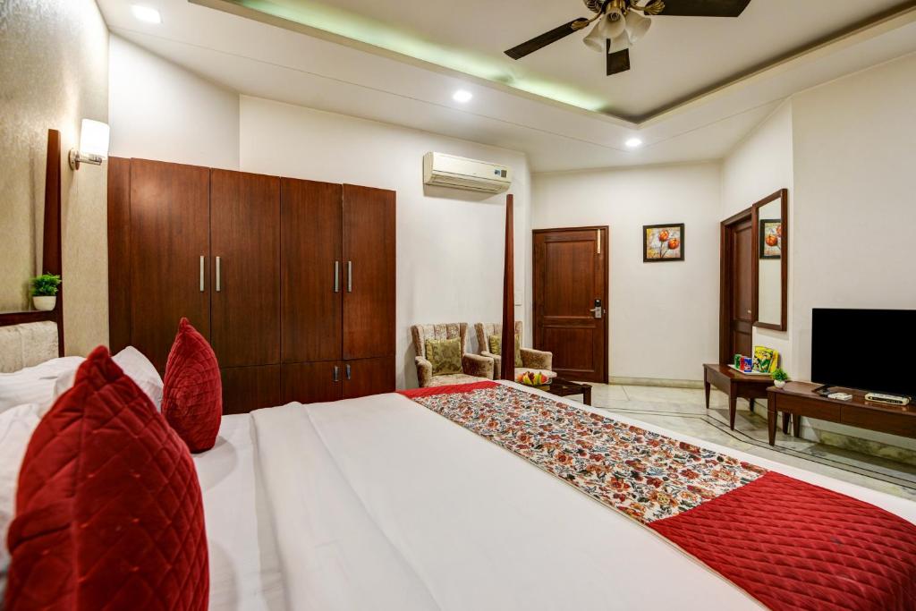a bedroom with a large white bed with red pillows at Monarch Residency Gurgaon in Gurgaon