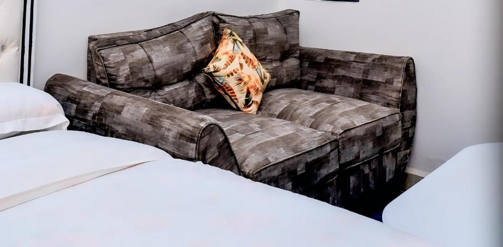 内罗毕Lunic Studio BNB的房间里摆放着一张棕色沙发和一个枕头