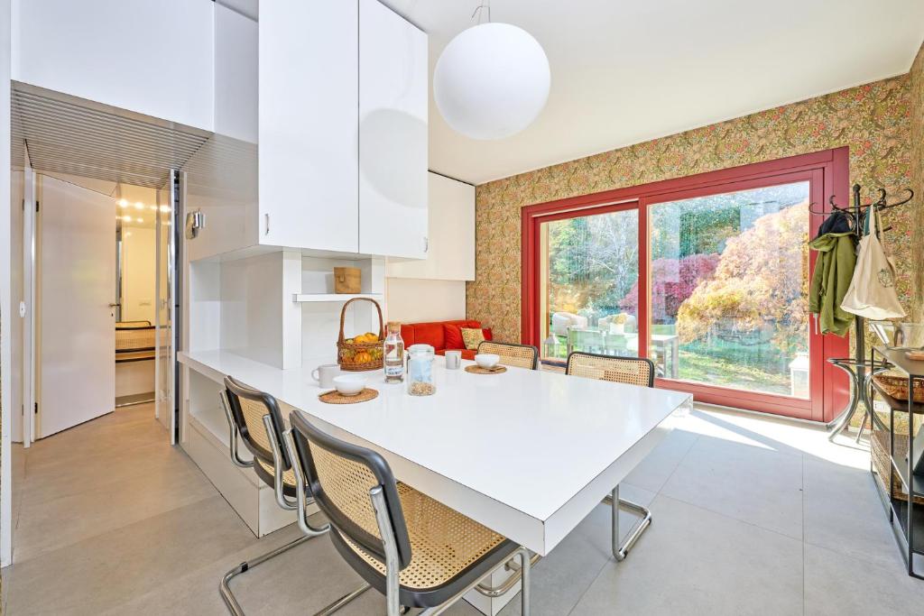 a kitchen and dining room with a white table and chairs at Casa Mora in Cerro Lago Maggiore