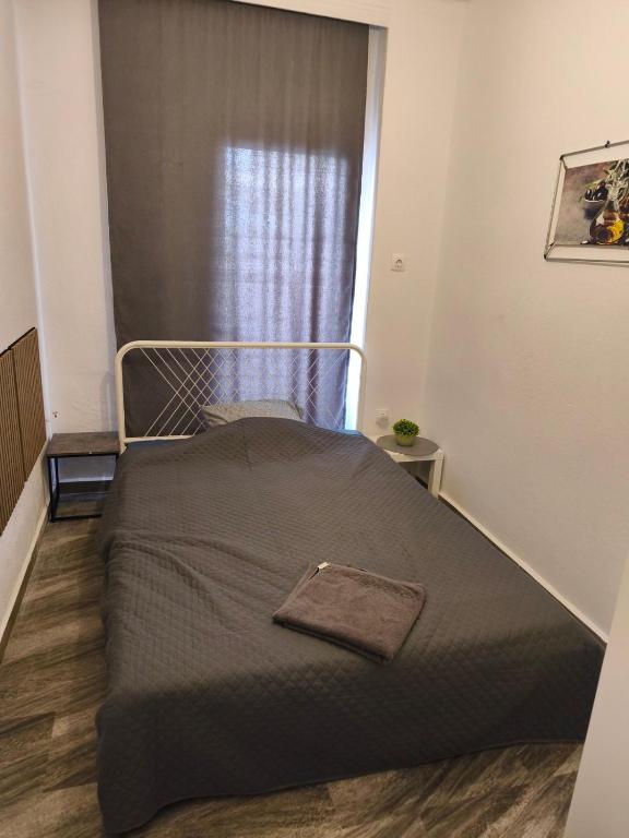 a bed in a small room with a window at Michaniona apartment in Nea Michaniona