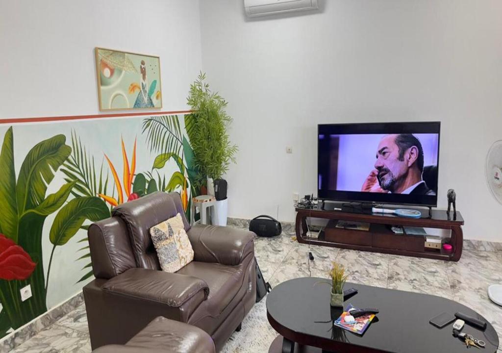 アシニにあるAKl RESIDENCEのソファと薄型テレビのあるリビングルーム