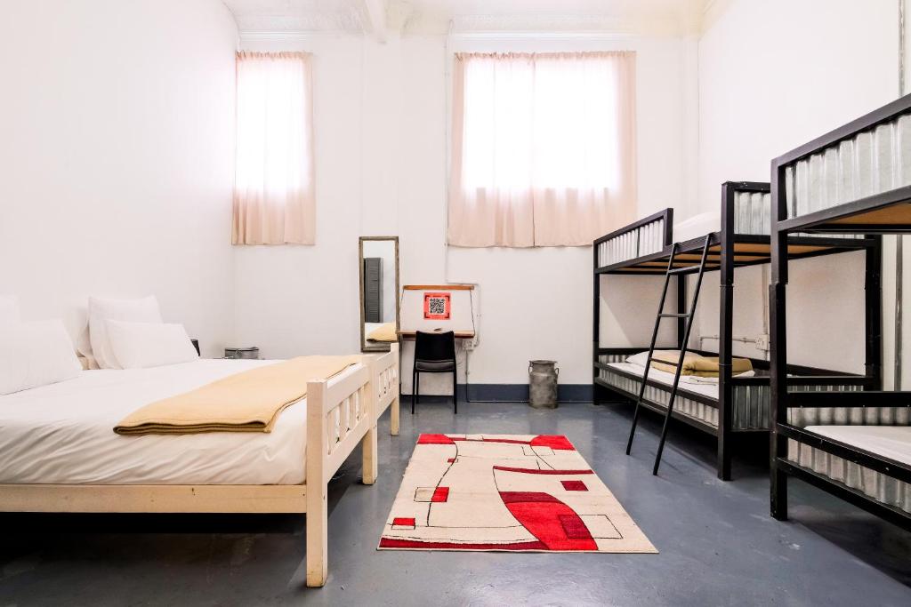 a room with two bunk beds and a table at CURIOCITY Backpackers Johannesburg in Johannesburg