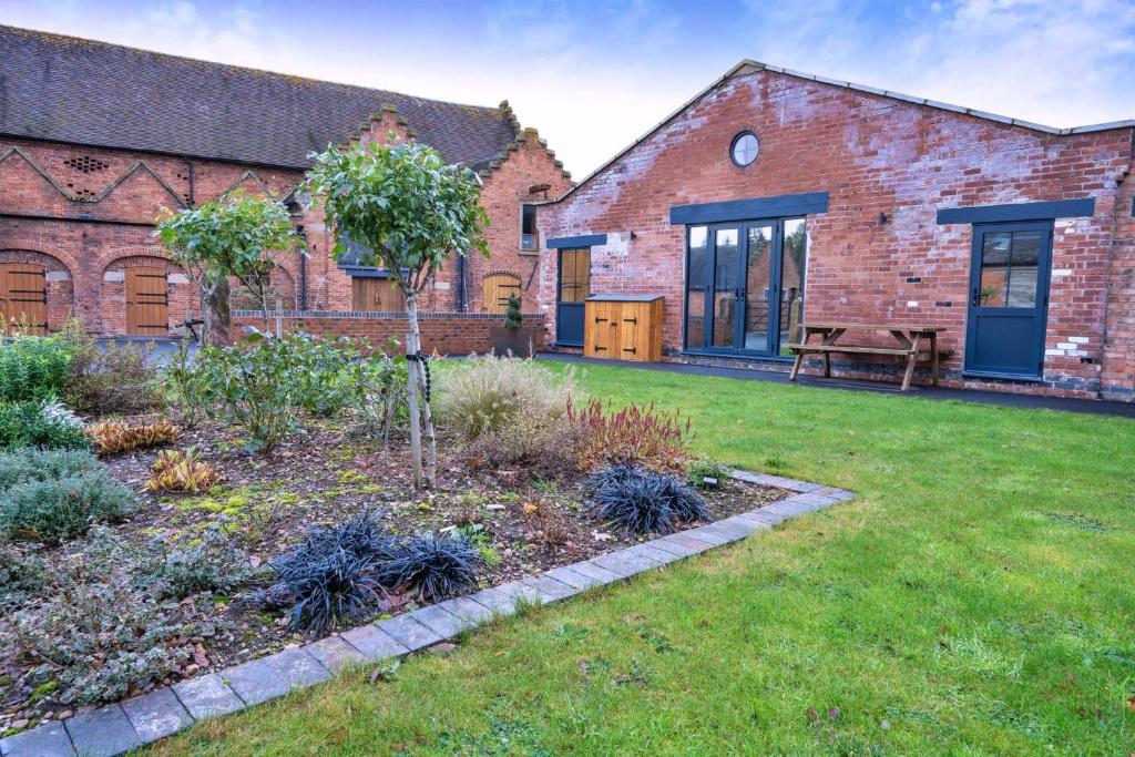 a garden in front of a brick building at Finest Retreats - Courtyard View at Longford in Hollington