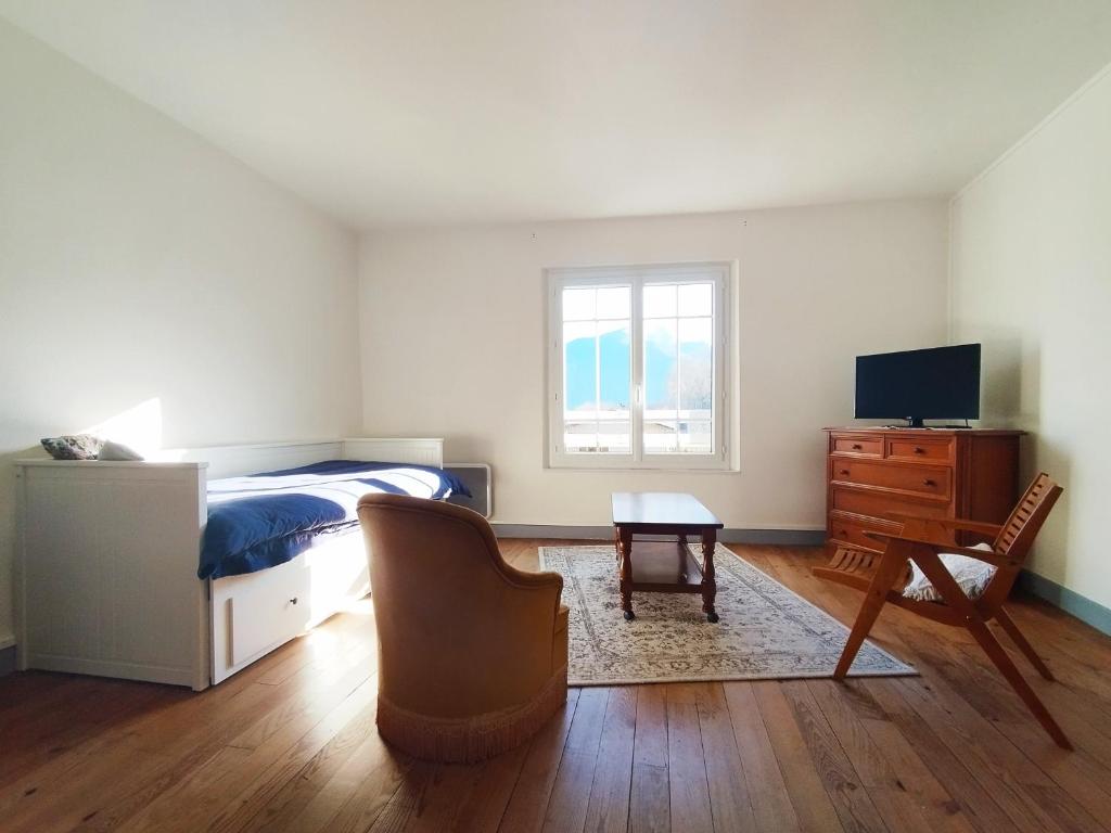 a bedroom with a bed and a desk and a chair at Gite La Tanière in Siradan