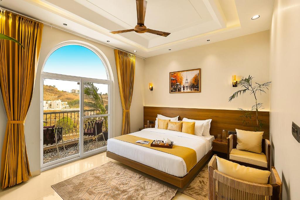 um quarto com uma cama e uma janela grande em ELIVAAS Le Aravella 3 BHK Villa with Gazebo, Balcony & Private Pool em Lakāwās