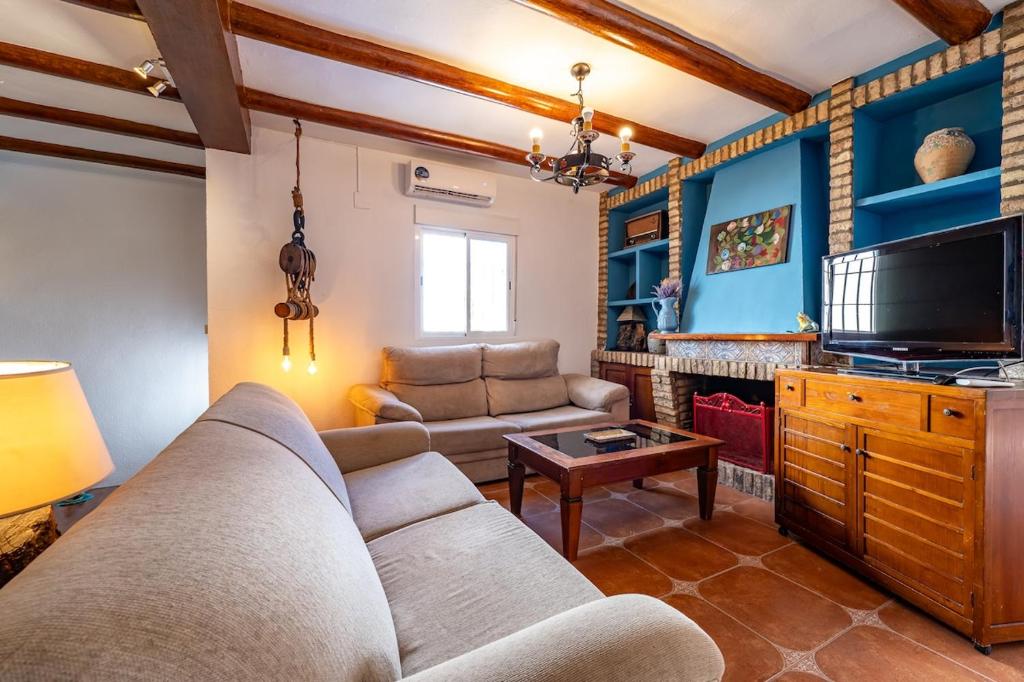 un soggiorno con un divano e una TV di Villa Marquesa - Punta Umbria a Punta Umbría