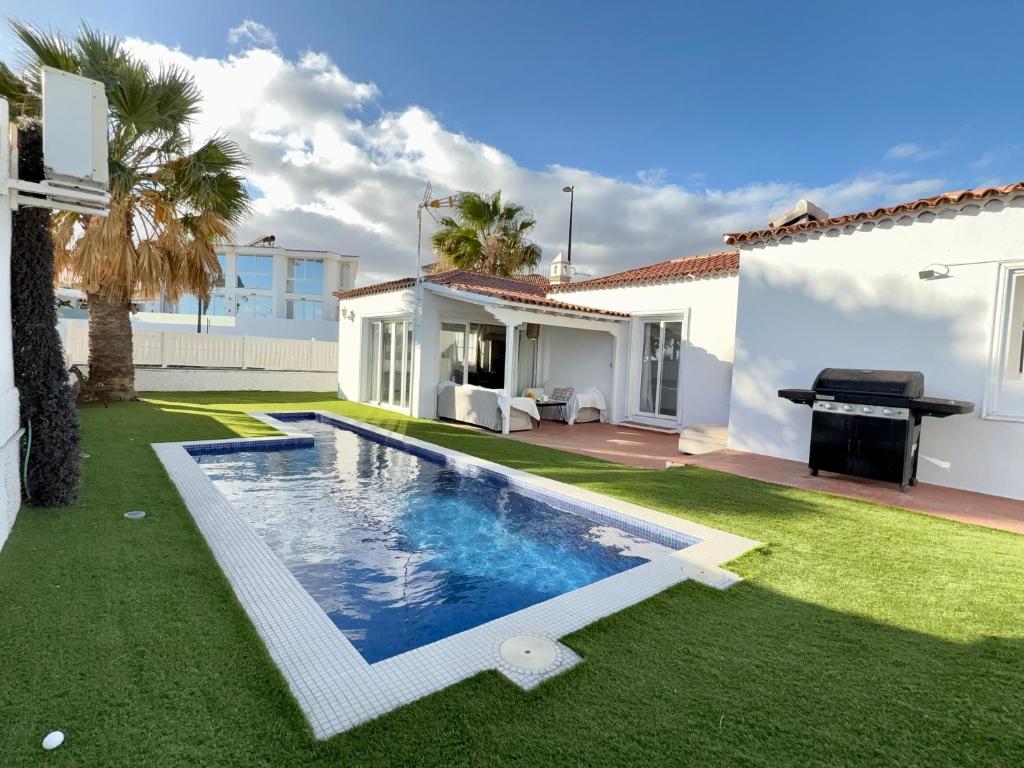 a backyard with a swimming pool and a house at Villa near the ocean with private pool and garage in San Miguel de Abona