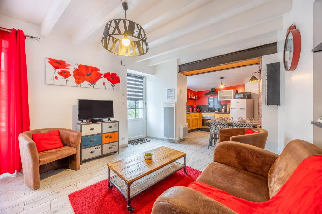 ein Wohnzimmer mit Sofa und Tisch in der Unterkunft Le Clemenceau in Les Épesses