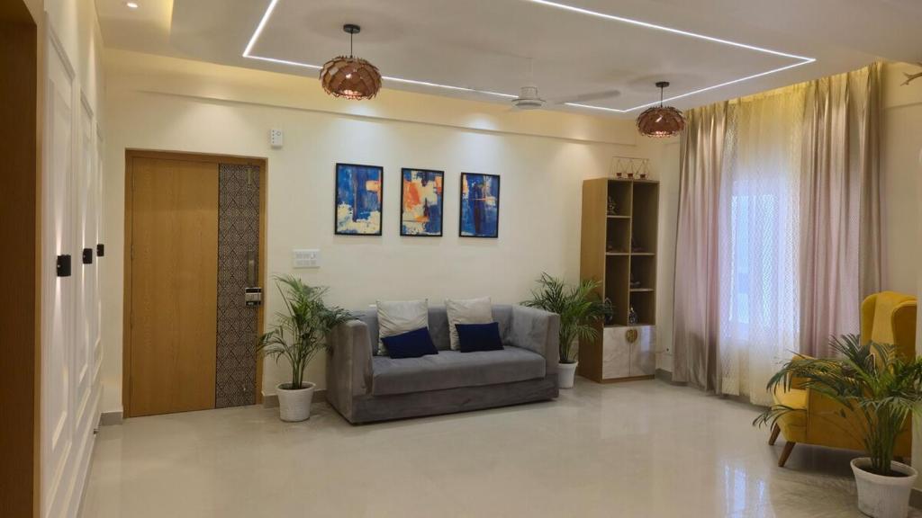 a living room with a couch and some plants at Spacious Lakeview Apartment with Balcony in Lucknow