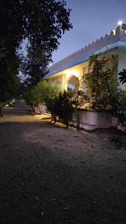 a house with trees and bushes next to a building at Jawai Rock Resort in Jawāi Bāndh