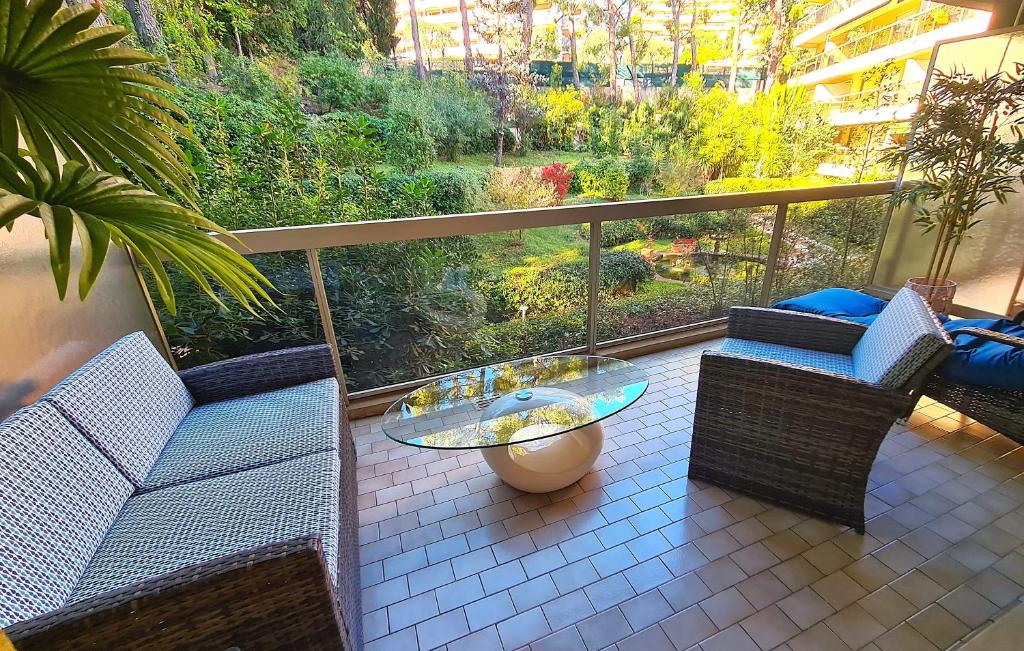 einen Balkon mit 2 Stühlen und einem Glastisch in der Unterkunft Studio grande terrasse à 5 min de la mer in Nizza