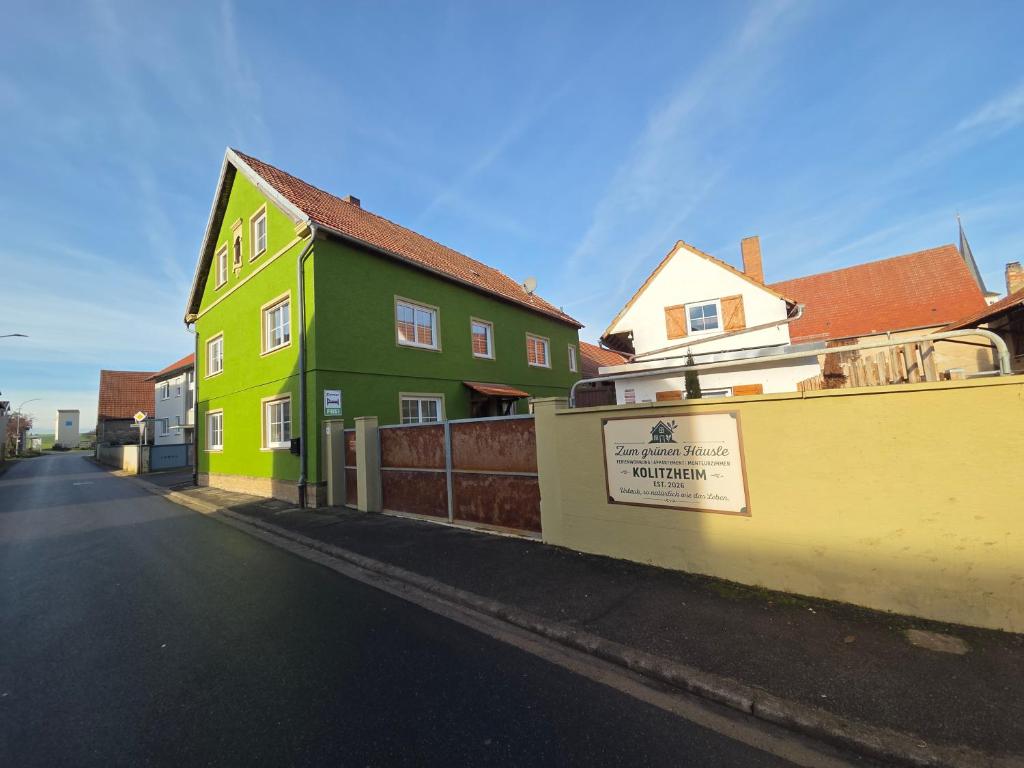 a green and yellow house on the side of a street at Zum grünen Häusle in Kolitzheim