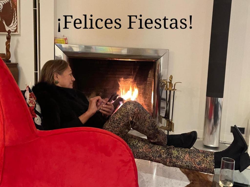 een vrouw in een stoel voor een open haard bij Villa Cela in Masnou