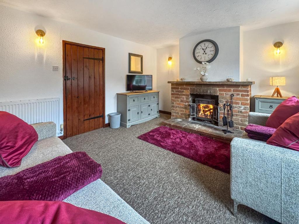 a living room with a fireplace and a couch at Jasmine Cottage - Uk50585 in Bintree