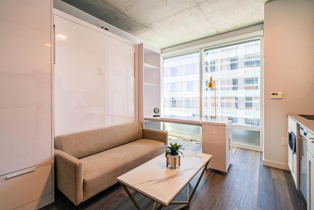 a living room with a couch and a table at Panoramic Studio-1BR-3BR, Pool, Gym, Parking, Patio, BBQ in Phoenix