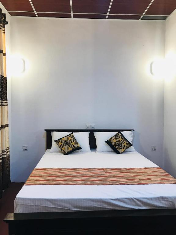 a bed with two pillows on it in a room at Shereen Sigiri Homestay in Dambulla