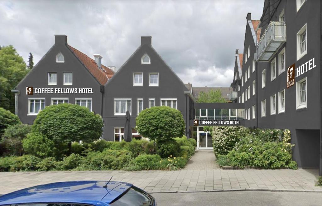 Un coche azul aparcado delante de un edificio en Coffee Fellows Hotel Puchheim, en Puchheim