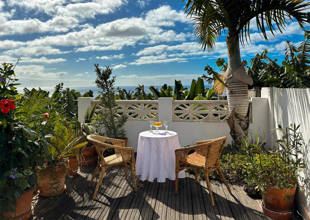 una mesa y sillas en un patio con una palmera en Casa Los Morros, en Tazacorte