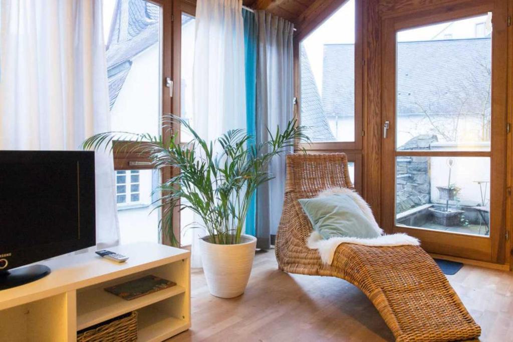 ein Wohnzimmer mit Korbstühlen und einem TV in der Unterkunft Altstadt Ferienwohnung Wagner in Limburg an der Lahn